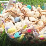 White Chocolate coated chex cereal mixed up with pretzel sticks and M&Ms makes Easter Bunny Chow thats sure to be a sweet, snacky hit with everyone at the table!