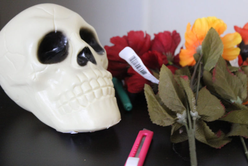 Make a DIY Skull Vase in under 5 minutes! Just cut a hole in the top of a plastic skull and fill with fake flowers!