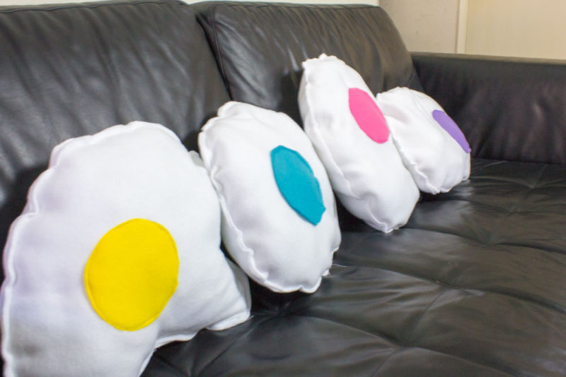 Add some comfy fun to your couch this spring with some DIY rainbow fried egg pillows! Easy sewing tutorial to make your own custom food throw pillow!