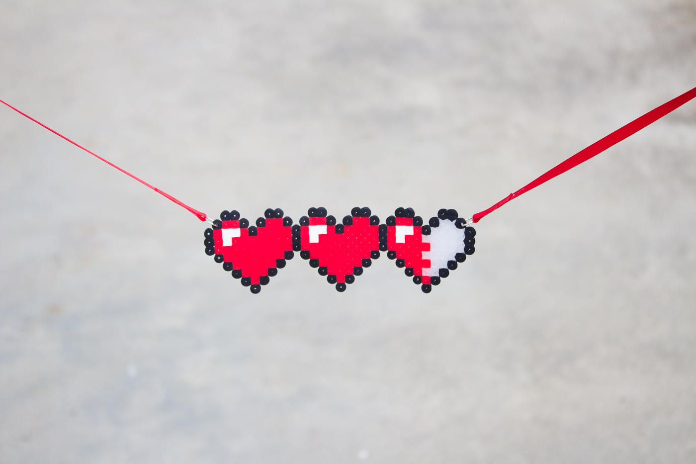 Let your geek flag fly with a DIY Legend of Zelda Pixel Heart Statment Necklace. Pull out some perler beads and your nintendo and party like it's 1986.