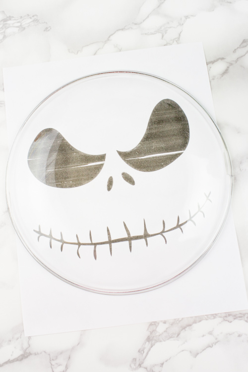 Scare up a good treat by making a simple DIY Jack Skellington Cake stand! Perfect for your Halloween decor or party tablescape! Dollar Store DIY! - Nightmare Before Christmas | Tim Burton | Food Safe | Halloween Projects | Party table - Doityourfreakingself.com